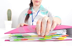 A medical worker opens a folder for accounting documents and cost estimates for medical materials for covid-19, close-up
