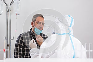 Medical worker in PPE performing nasal swab COVID-19 test in hospital lab