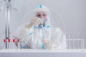 Medical worker in PPE working with COVID-19 test in hospital lab