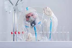 Medical worker in PPE working with COVID-19 test in hospital lab