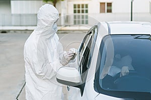 Medical worker in protective suit screening woman Driver to Sampling secretion to check for Covid-19. check,taking nasal swab