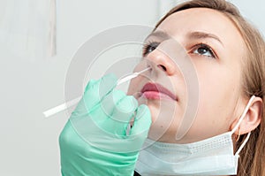 Medical worker taking a swab for corona virus sample from potentially infected woman. Coronavirus test