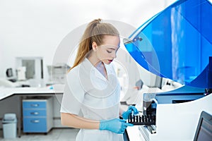 A medical worker works in an auto-biochemical and immune enzyme analyzer in the laboratory of the clinic.