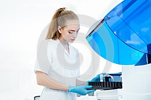 A medical worker works in an auto-biochemical and immune enzyme analyzer in the laboratory of the clinic.