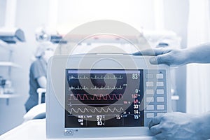 Medical workers connecting critical patient to the heart monitor in the intensive care unit