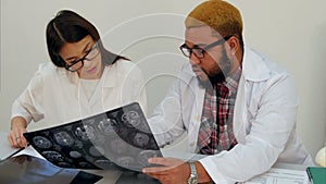 Medical workers discussing brain computed tomography x-ray image