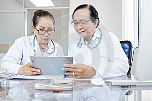 Medical workers discussing data on tablet computer