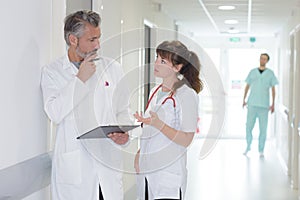 Medical workers in discussion in hospital corridor