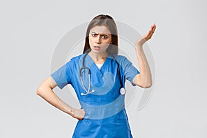 Medical workers, healthcare, covid-19 and vaccination concept. Frustrated and confused young female nurse, pretty doctor