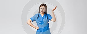 Medical workers, healthcare, covid-19 and vaccination concept. Frustrated and confused young female nurse, pretty doctor