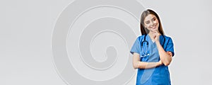 Medical workers, healthcare, covid-19 and vaccination concept. Upbeat smiling pretty nurse, doctor in blue scrubs
