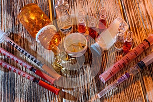 Medicaments in ampoules and syringes on wooden background