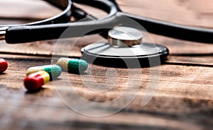 Medicare for all. Capsules and stethoscope wooden background. Medicare prescription drugs