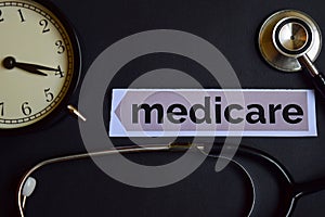 Medicare on the print paper with Healthcare Concept Inspiration. alarm clock, Black stethoscope.