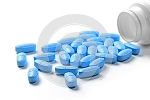 Medication bottle with blue pills isolated