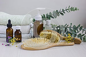 Medication bottles, hairbrush and towel on white wooden table. Hair loss problem.