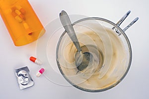Medication during breakfast, capsules next to a glass of coffee, conceptual image