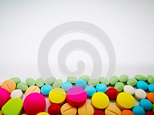 Medication and healthcare concept. Heap of colorful tablets medicine. Isolated on white background, selective focus and copy