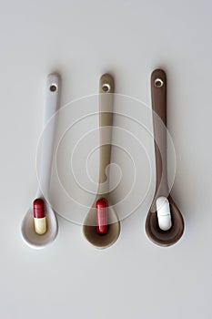 medication pills inside ceramic spoons. drugs, antibiotics, analgesics, narcotics