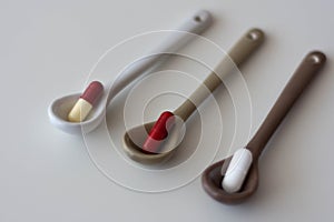 medication pills inside ceramic spoons. drugs, antibiotics, analgesics, narcotics photo