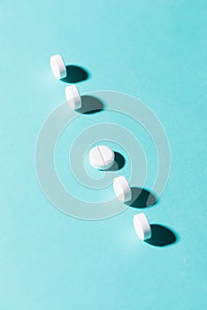 Medication pills in a row against a blue background.