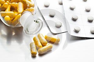 Medications as various capsules on a metal table