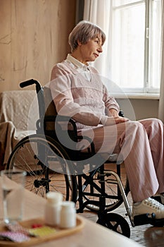 Medications and recovery pills with glass of water on table for old patient