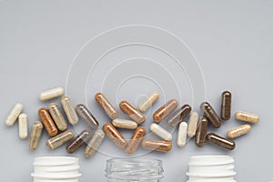 Medicinal capsule spill out of a three plastic bottles on a ligh