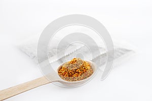 Medicinal herbal tea leafs in a wooden spoon and tea bags on white background. Health and beauty concept.