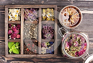 Medicinal herbs in a wooden box and a glass jar for herbal tea and tinctures.