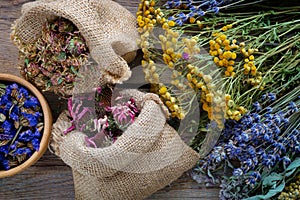 Medicinal herbs, wooden mortar and two bags of dry flowers
