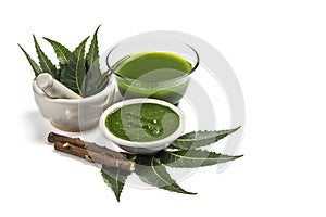 Medicinal Neem leaves in mortar and pestle with neem paste, juice and twigs