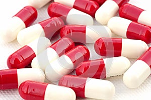 Medicinal pills piled on white background.