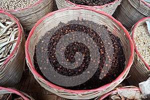Dried Cloves in bamboo basket. medicinal plants. Thai herbs. photo