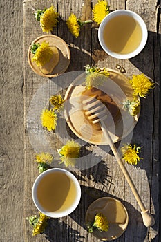 Medicinal Tea from dandelion in   cup with honey dandelion on rustic  wooden table  with copy space