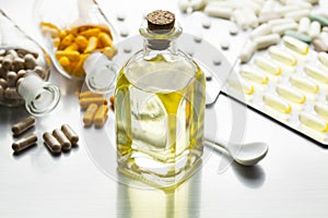 Medicine as a syrup in a glass bottle and various capsules