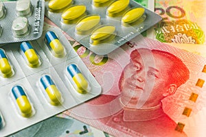 Medicine blister pack on Chinese cash banknotes background. World economy crisis, fix or solution U.S. vs China dispute trade war