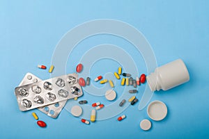 Medicine bottle, blister pack and pills closeup on blue background