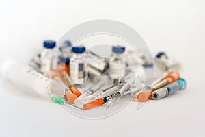 Medicine bottles, ampules and syringes on white background with copy space for text, treatment medication concept closeup