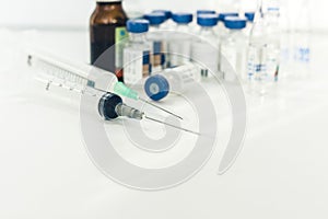 Medicine bottles, ampules and syringes on white background with copy space for text, treatment medication concept closeup