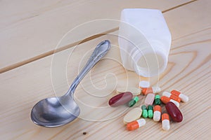 Medicine bottles and medicines Lay on a wooden floo photo