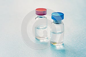 Medicine in bottles with red and blue capsule. On blue background. Copy space