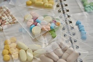 Medicine in clear plastic bag on notebook background.