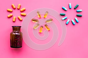 Medicine. Color capsules near pill bottle on pink background top view copy space. fireworks of flower shape