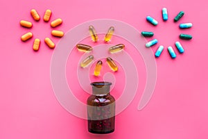 Medicine. Color capsules near pill bottle on pink background top view copy space. fireworks of flower shape