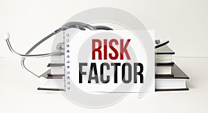 Medicine concept. Blackboard with word RISK FACTOR and stethoscope on wooden background