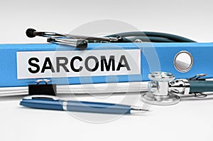 On the book is a stethoscope and a folder with the inscription - SARCOMA