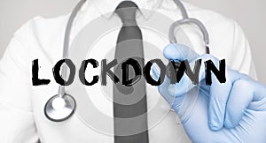 Medicine concept. Doctor writes the word LOCKDOWN . Image of a hand holding a marker isolated on a white background