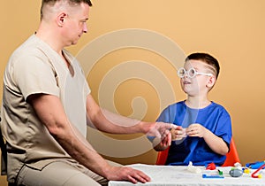Medicine concept. Kid little doctor sit table medical tools. Health care. Medical examination. Boy cute child and his photo