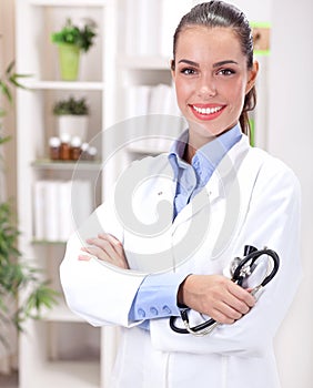 medicine concept - smiling female doctor with heart and stethoscope